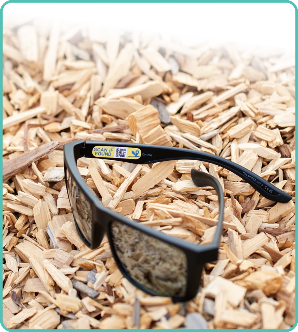 A pair of sunglasses left on wood chips, tagged with a Zenhoko code